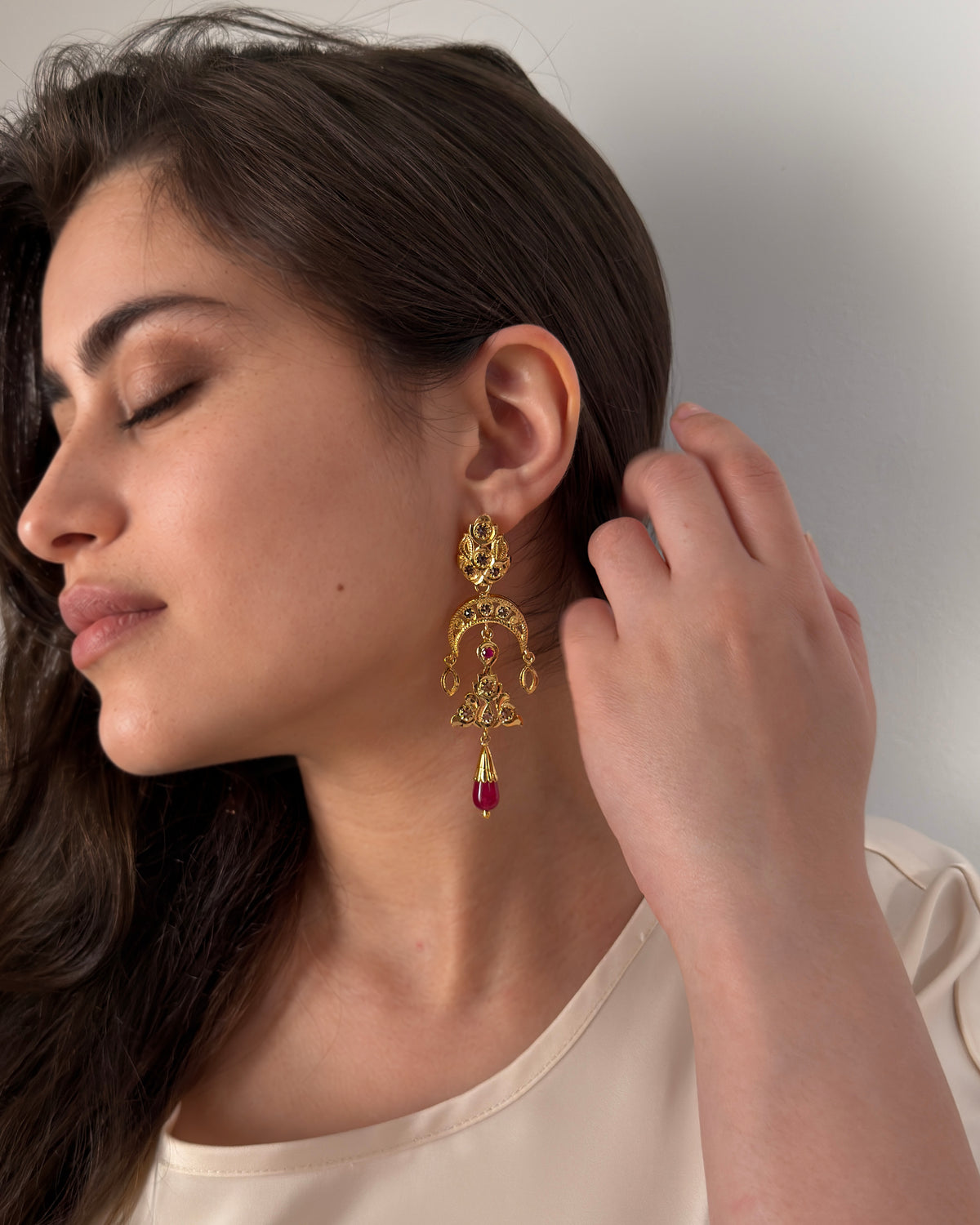Handcrafted Moroccan gold-plated sterling silver earring with red cabochon worn on model