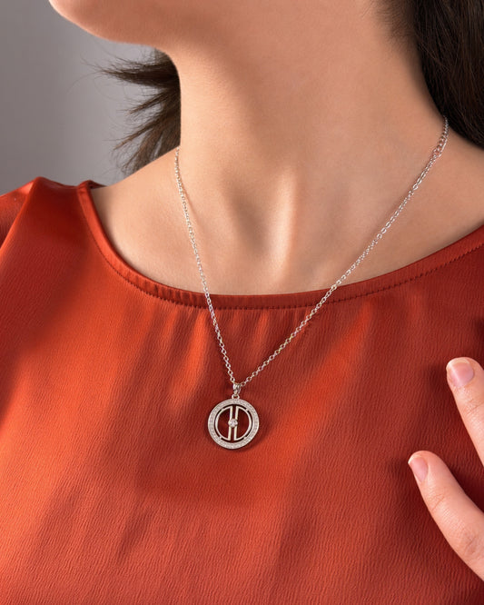 Woman wearing a rhodium-plated silver moon necklace on a terracotta top, showing the pendant size and everyday styling.