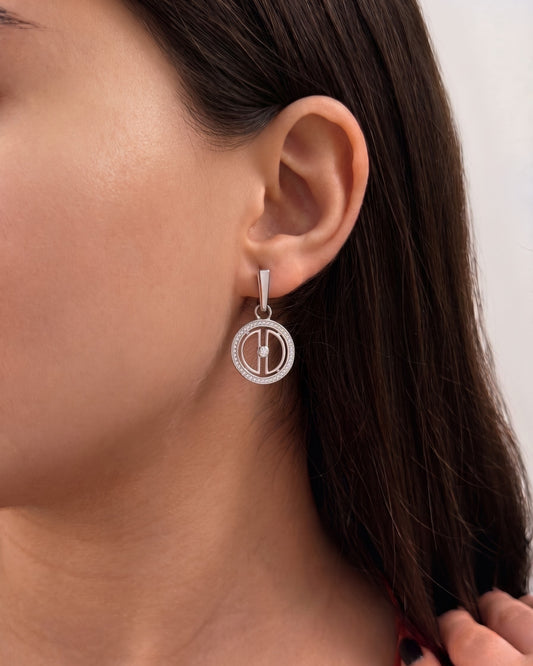 Close-up of a woman wearing rhodium-plated sterling silver moon earrings with sparkling zirconia details, showing the elegant size when worn.