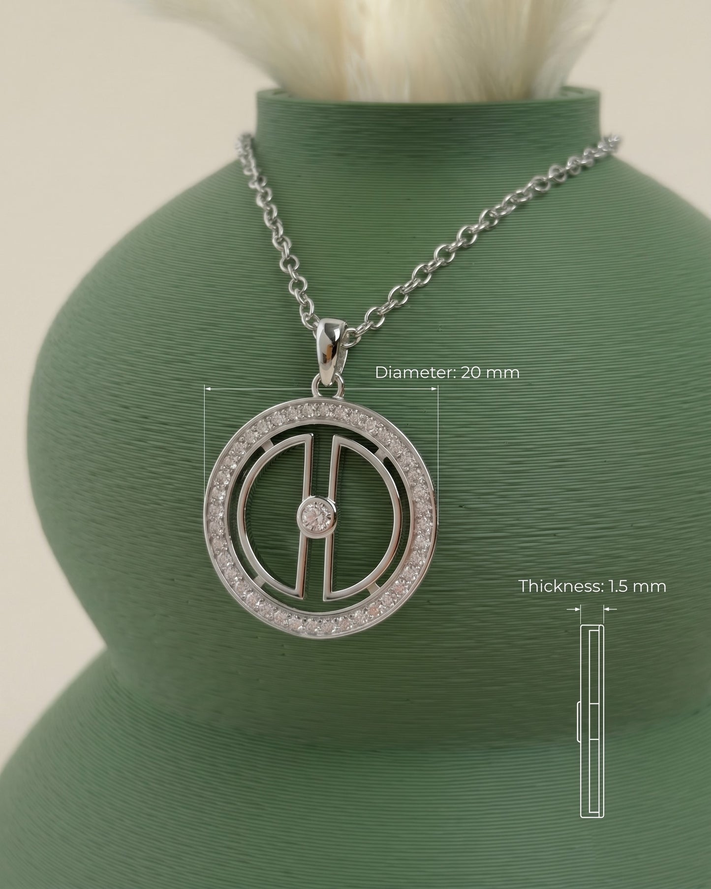 Rhodium-plated silver moon necklace displayed on a green vase with measurement details showing a 20 mm pendant diameter and 1.5 mm thickness.