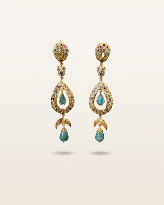 Pair of Moroccan sterling silver drop earrings with gold plating, multicoloured stones and green cabochons on an ivory background.