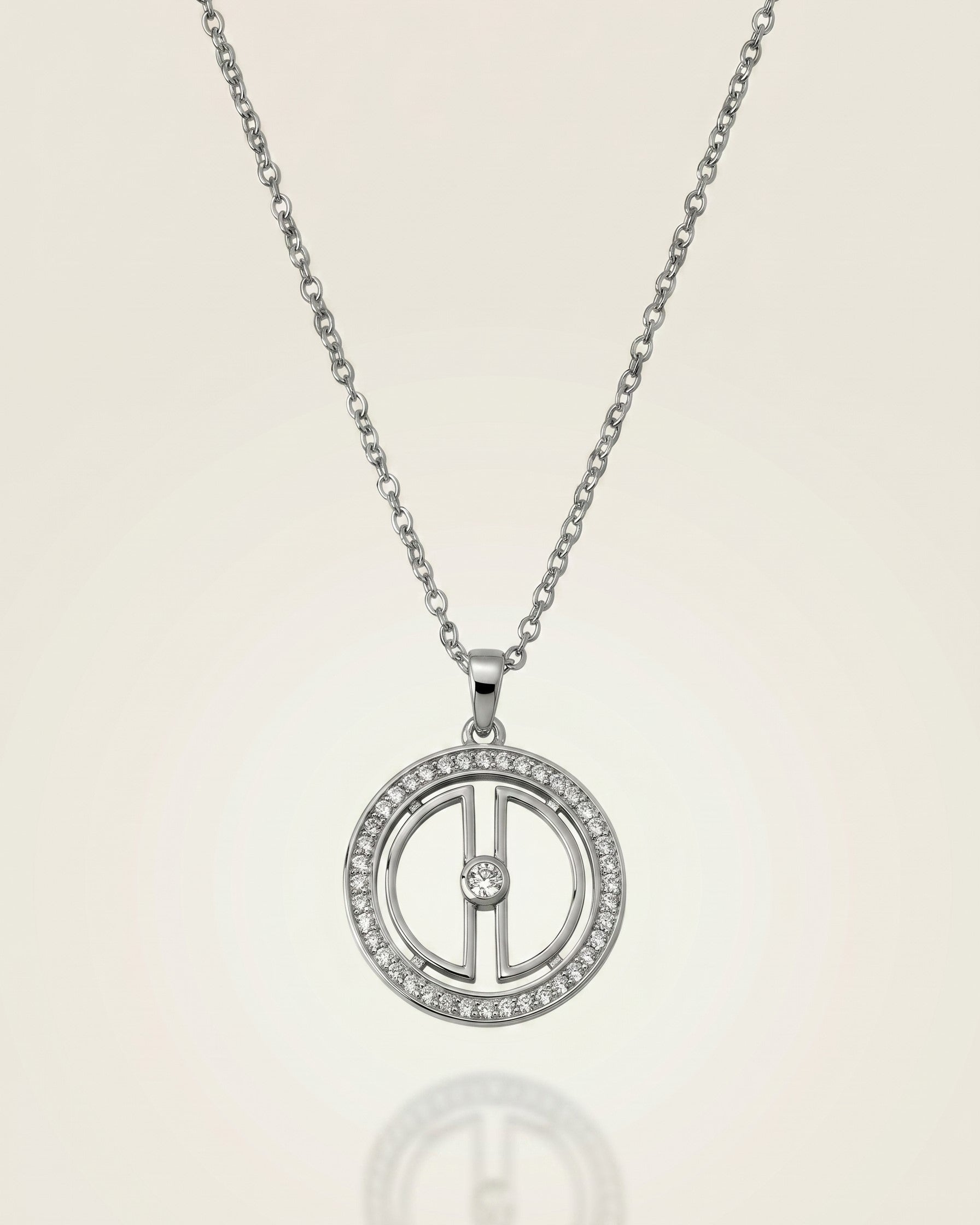 Clear product photo of a rhodium-plated sterling silver moon necklace with cubic zirconia details and a soft reflective background.