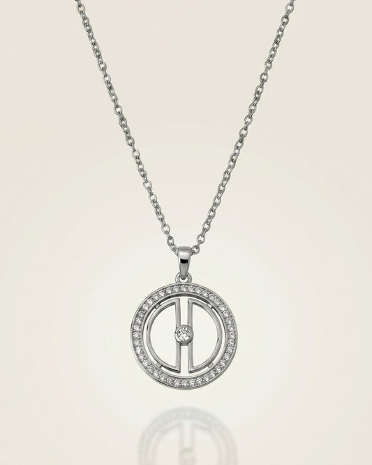 Clear product photo of a rhodium-plated sterling silver moon necklace with cubic zirconia details and a soft reflective background.