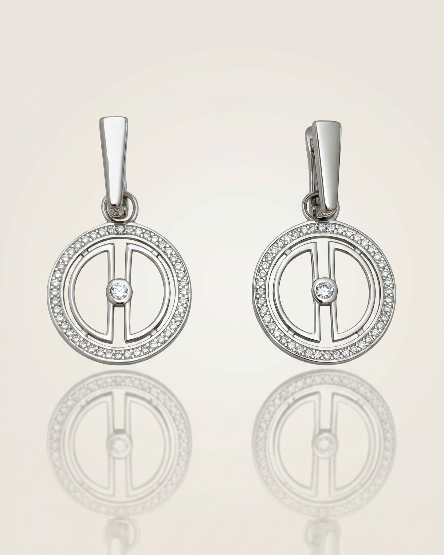 Pair of rhodium-plated sterling silver moon earrings with sparkling cubic zirconia details, displayed on a clean reflective surface.