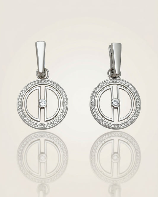 Pair of rhodium-plated sterling silver moon earrings with sparkling cubic zirconia details, displayed on a clean reflective surface.