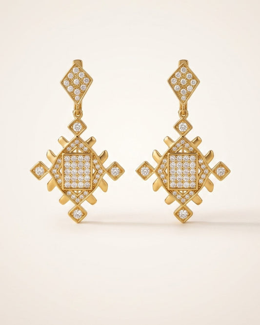 Pair of gold Lion’s Paw statement earrings with sparkling cubic zirconia details displayed on a soft neutral background.