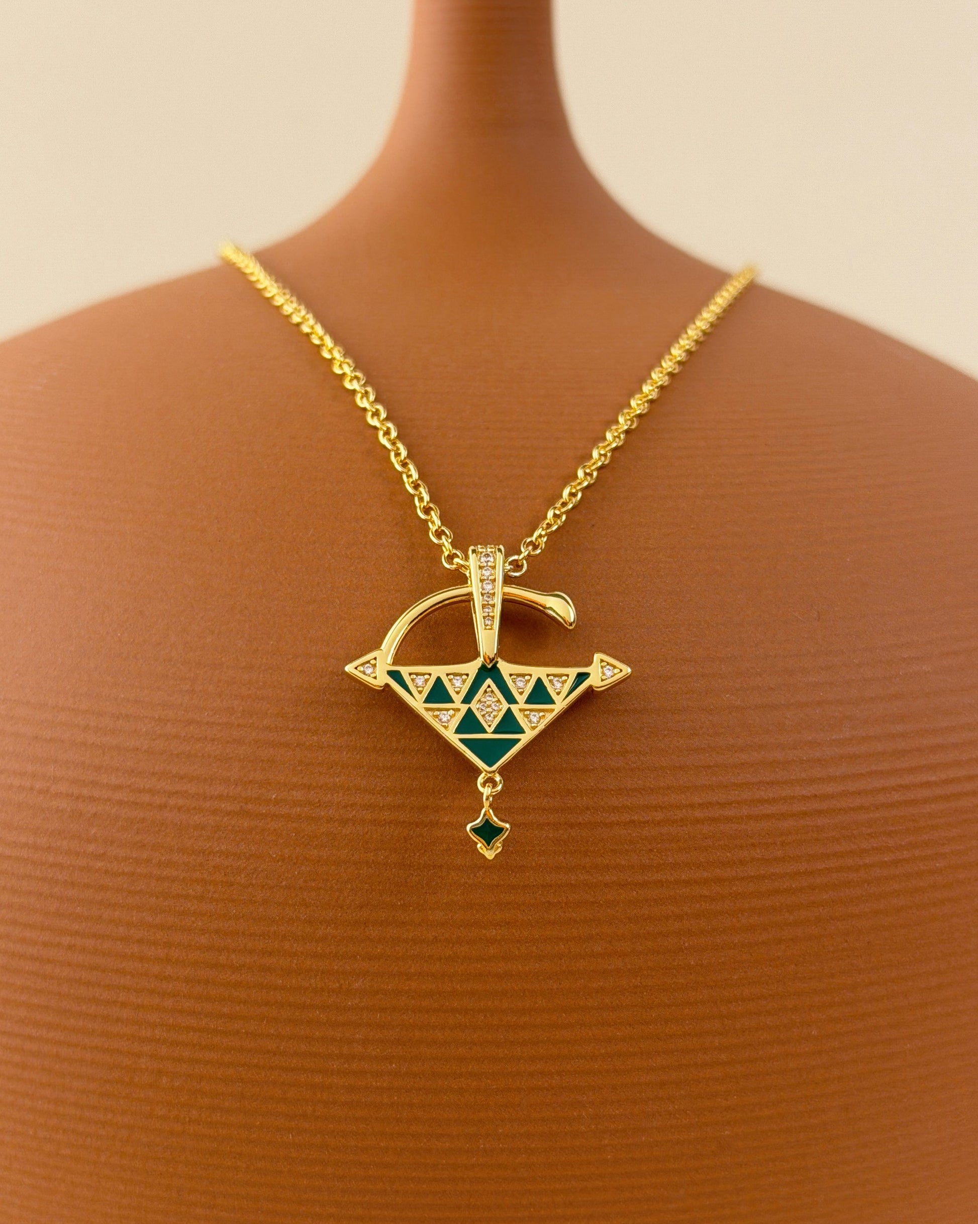 Gold vermeil Tizerzit necklace with green enamel and cubic zirconia details displayed on a warm terracotta bust.