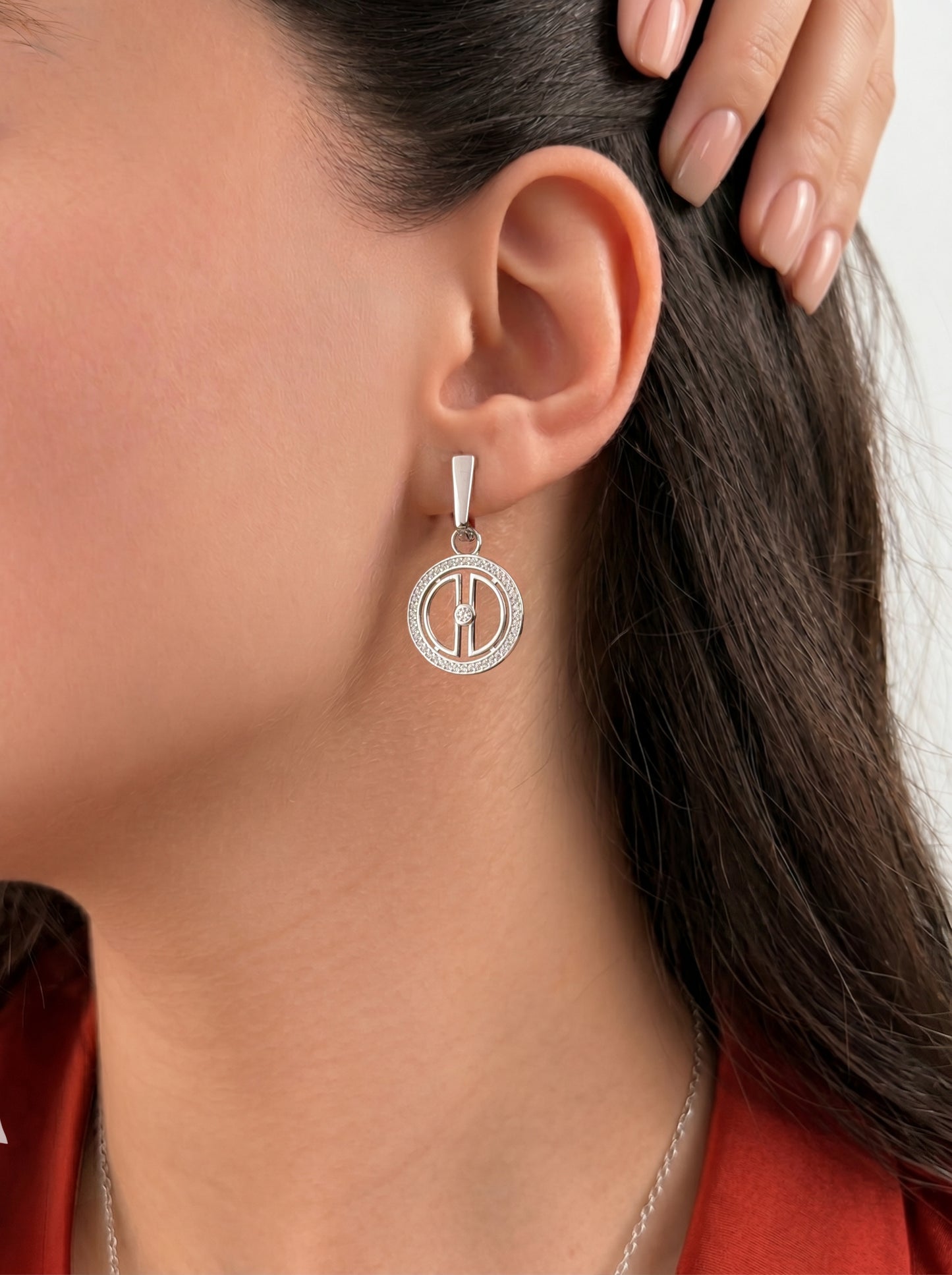 Lifestyle close-up of rhodium-plated silver moon drop earrings worn on the ear, highlighting the shine, shape, and celestial pendant design.