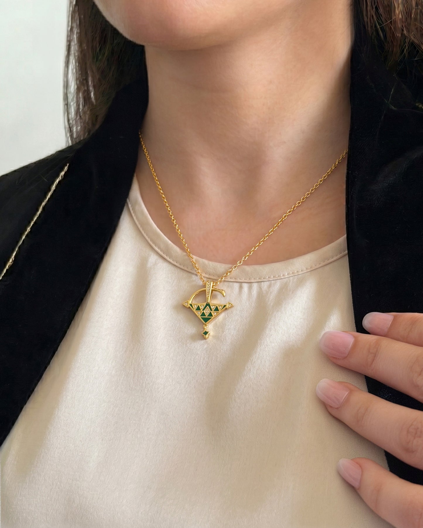 Woman wearing a gold vermeil Tizerzit necklace with green enamel details, showing the pendant size and elegant everyday styling.
