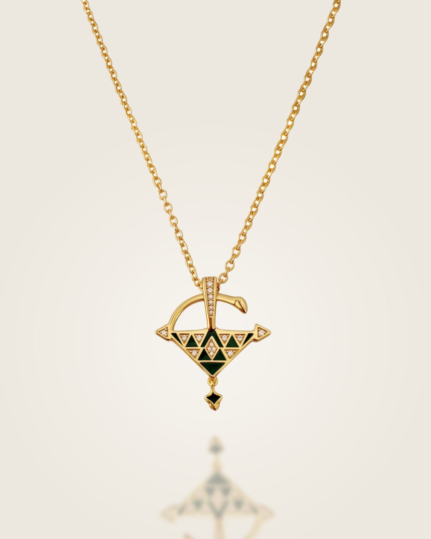 Gold vermeil Tizerzit necklace with green enamel pendant displayed against a soft neutral background with a subtle reflection.