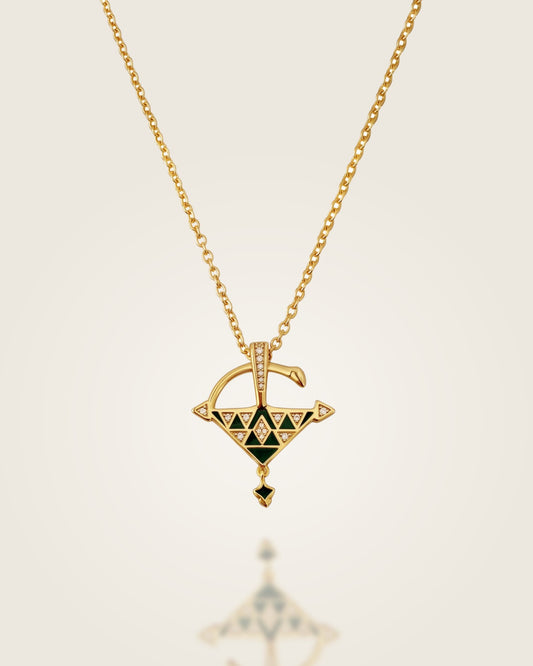 Gold vermeil Tizerzit necklace with green enamel pendant displayed against a soft neutral background with a subtle reflection.