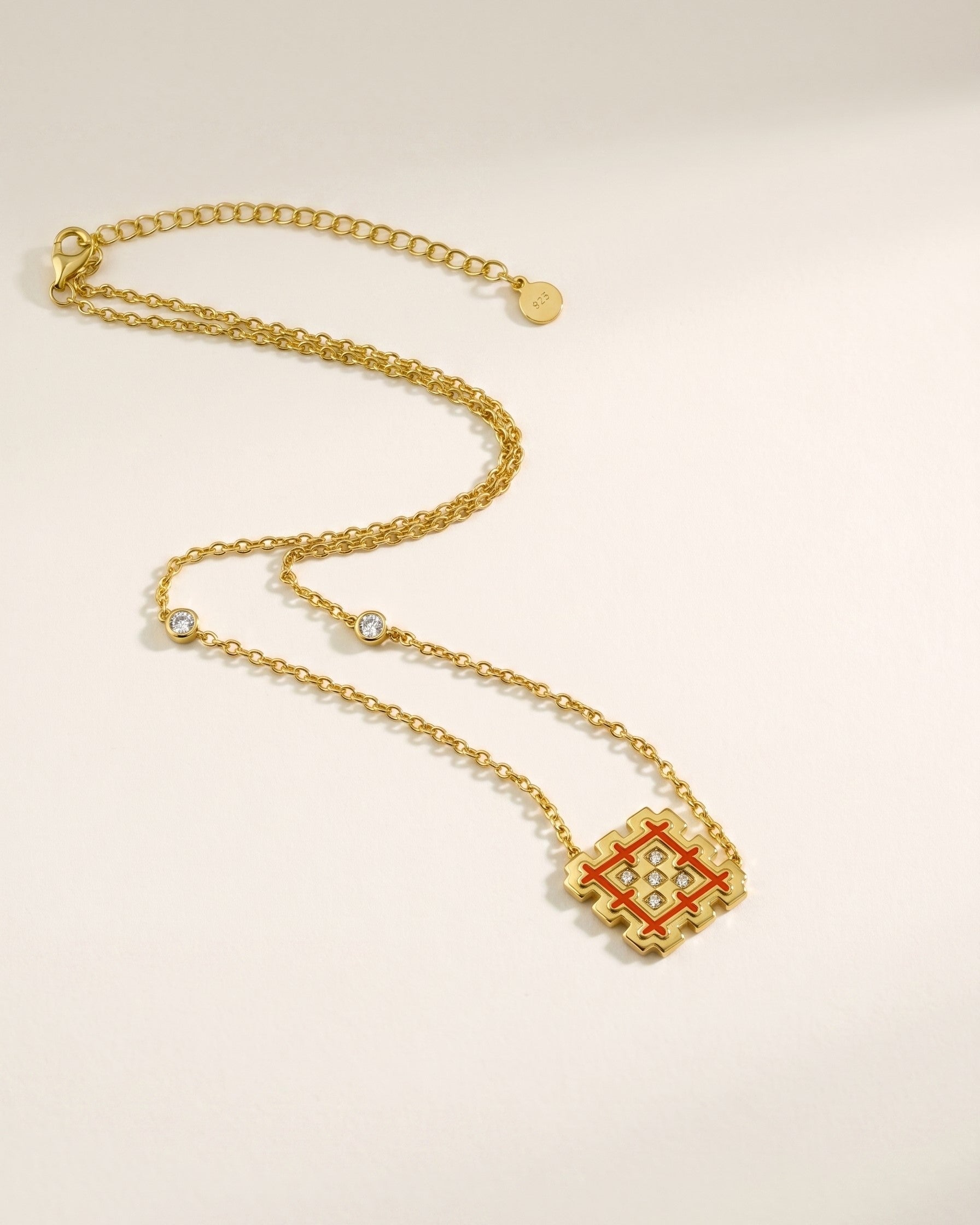 Full view of a gold vermeil Lion’s Paw necklace with orange enamel, showing the adjustable chain, station stones, and 925 silver tag.