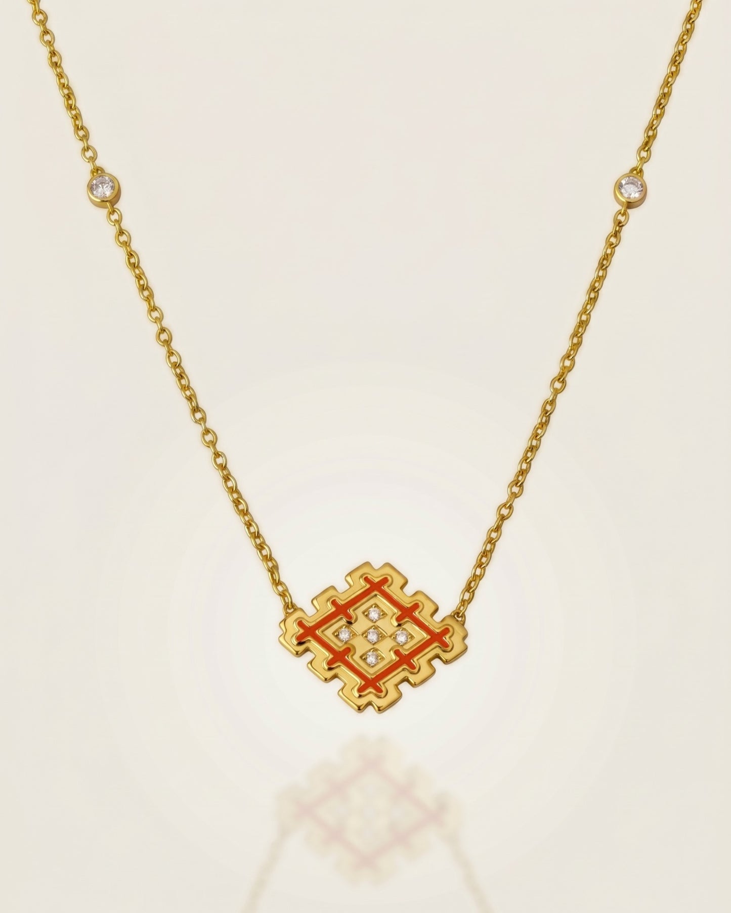 Orange enamel Lion’s Paw pendant necklace in gold vermeil with cubic zirconia details, displayed on a soft neutral background with subtle reflection.