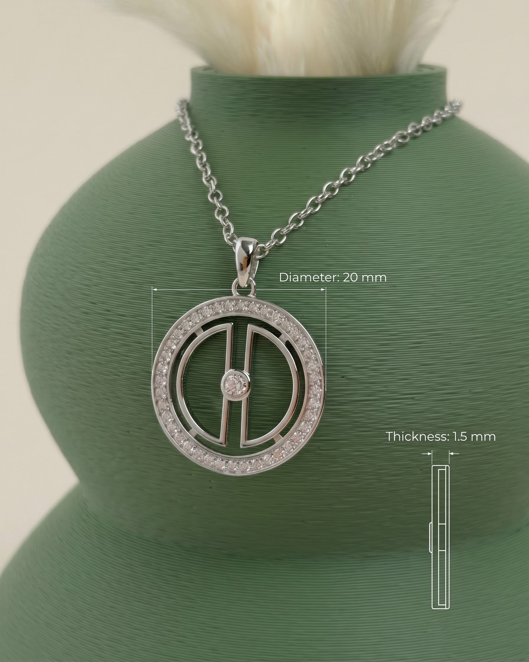 Rhodium-plated silver moon necklace displayed on a green vase with measurement details showing a 20 mm pendant diameter and 1.5 mm thickness.