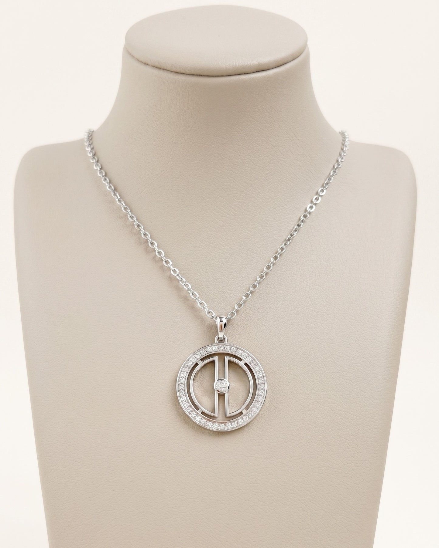 Silver moon necklace with rhodium-plated finish displayed on a white jewelry bust, highlighting the round pendant design.