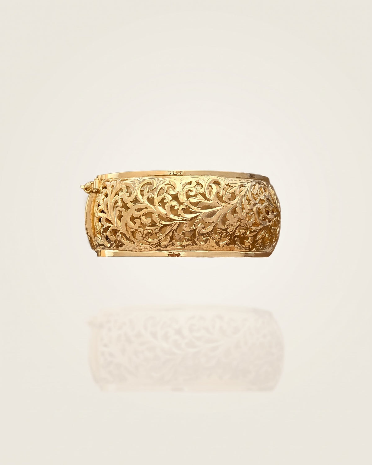 Front view of the Amuris Arabesque gold-plated silver bracelet with botanical openwork on an ivory background.
