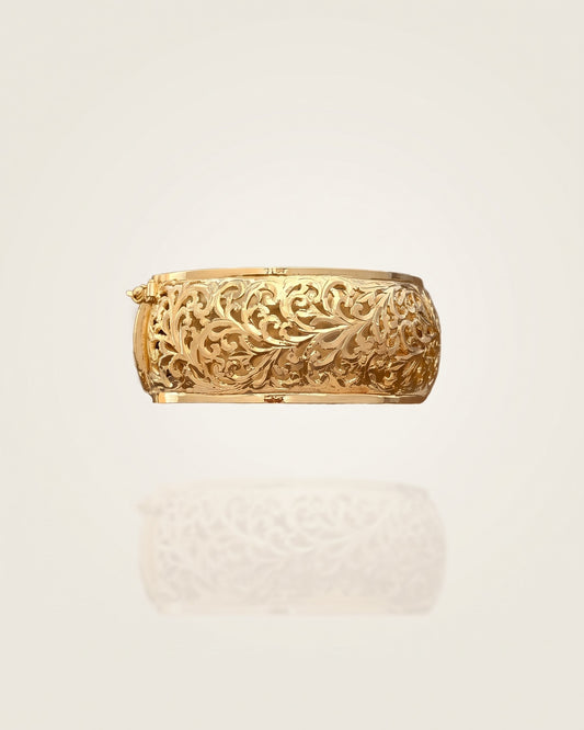 Front view of the Amuris Arabesque gold-plated silver bracelet with botanical openwork on an ivory background.