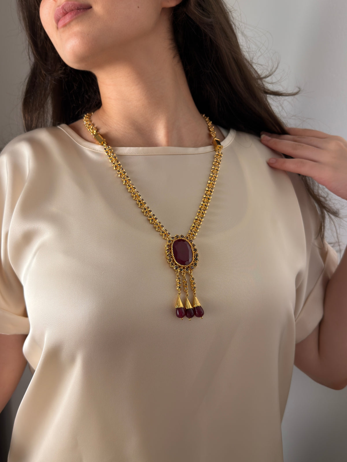 Close-up of Moroccan gold-plated sautoir necklace with red cabochon and three red drops