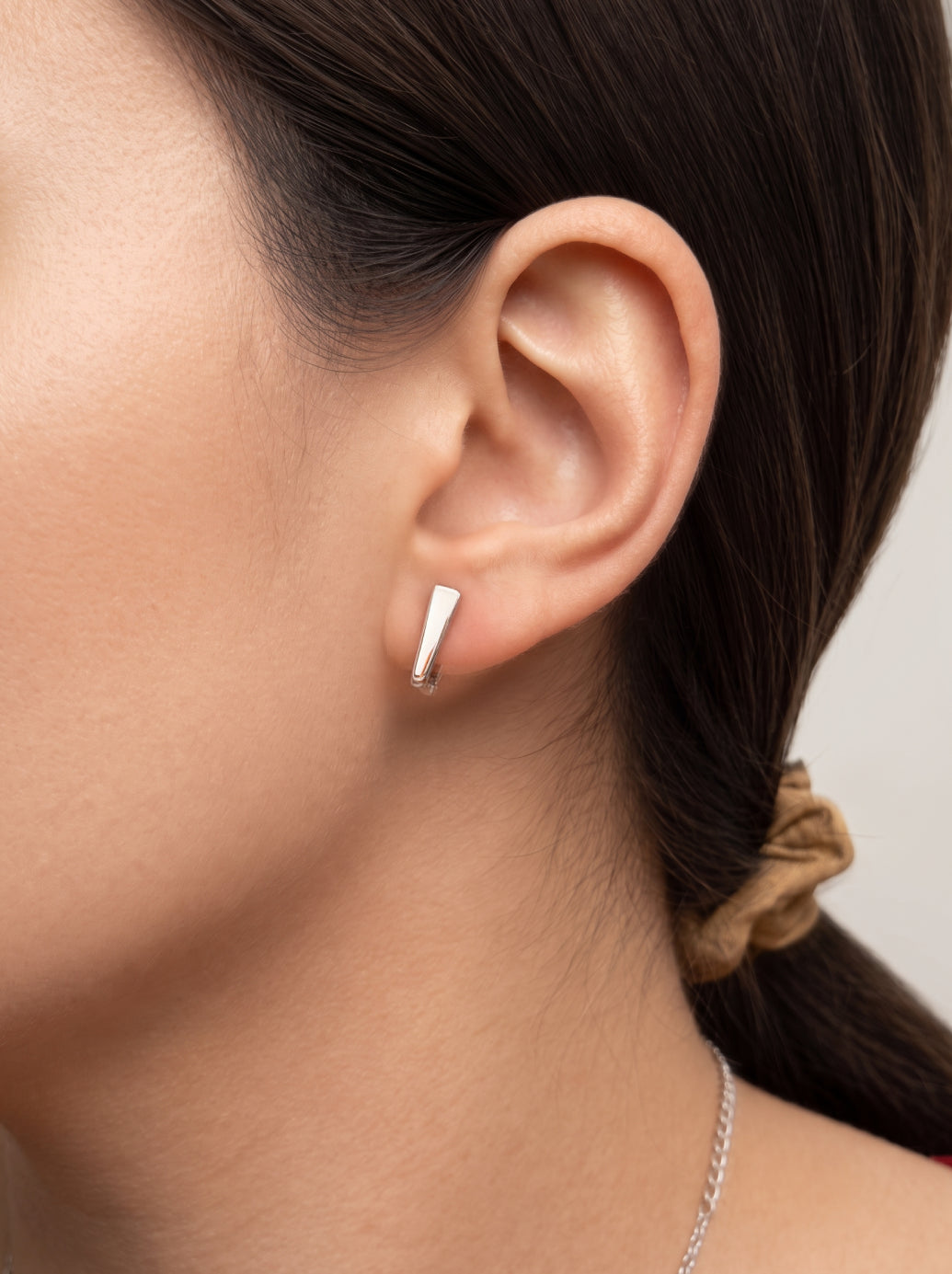 Rhodium-plated sterling silver hoop earring worn without the moon charm, showing the convertible two-in-one design for everyday styling.